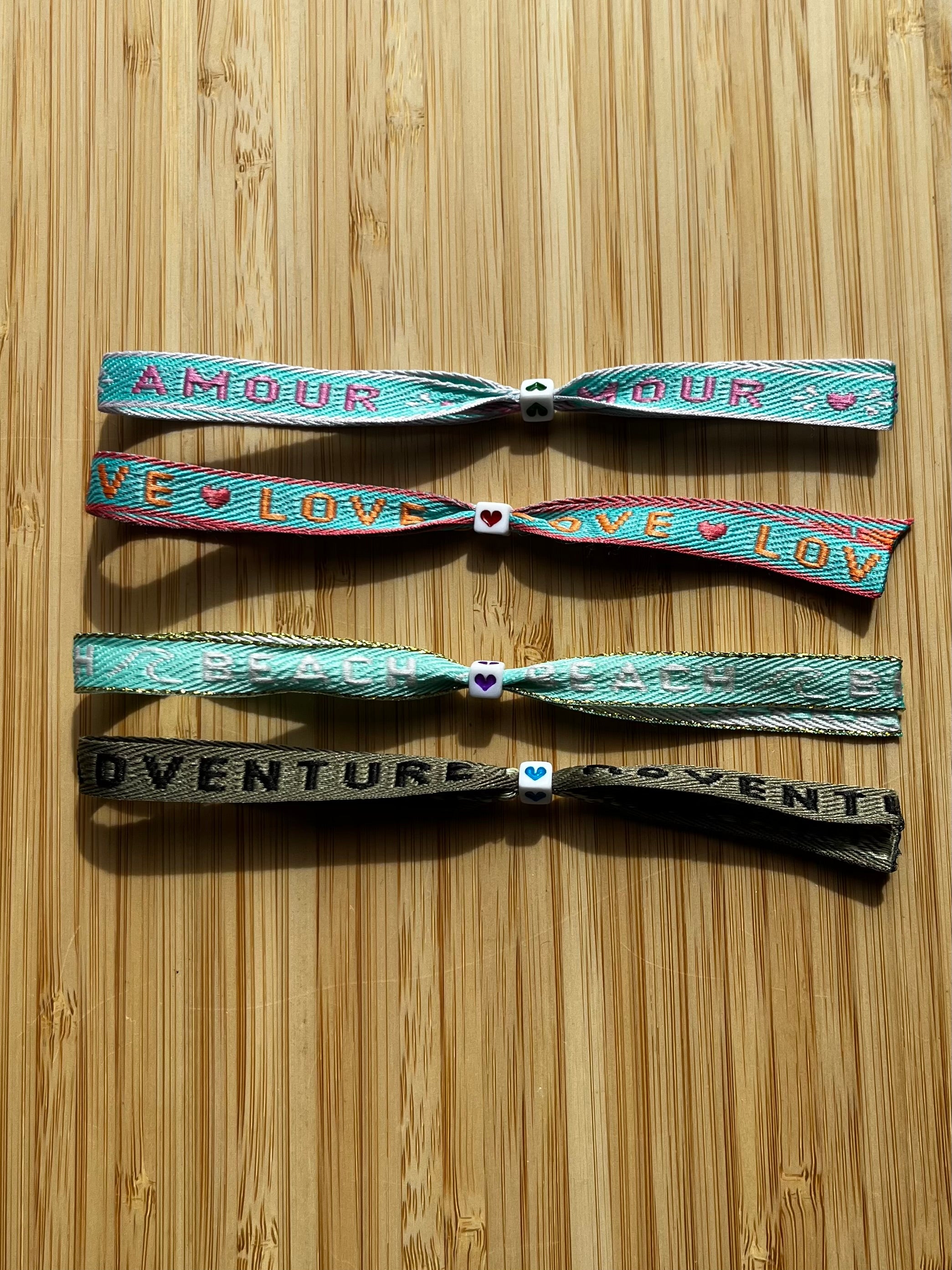 Zomerse lintarmbandjes met tekst in blauw/groene kleuren