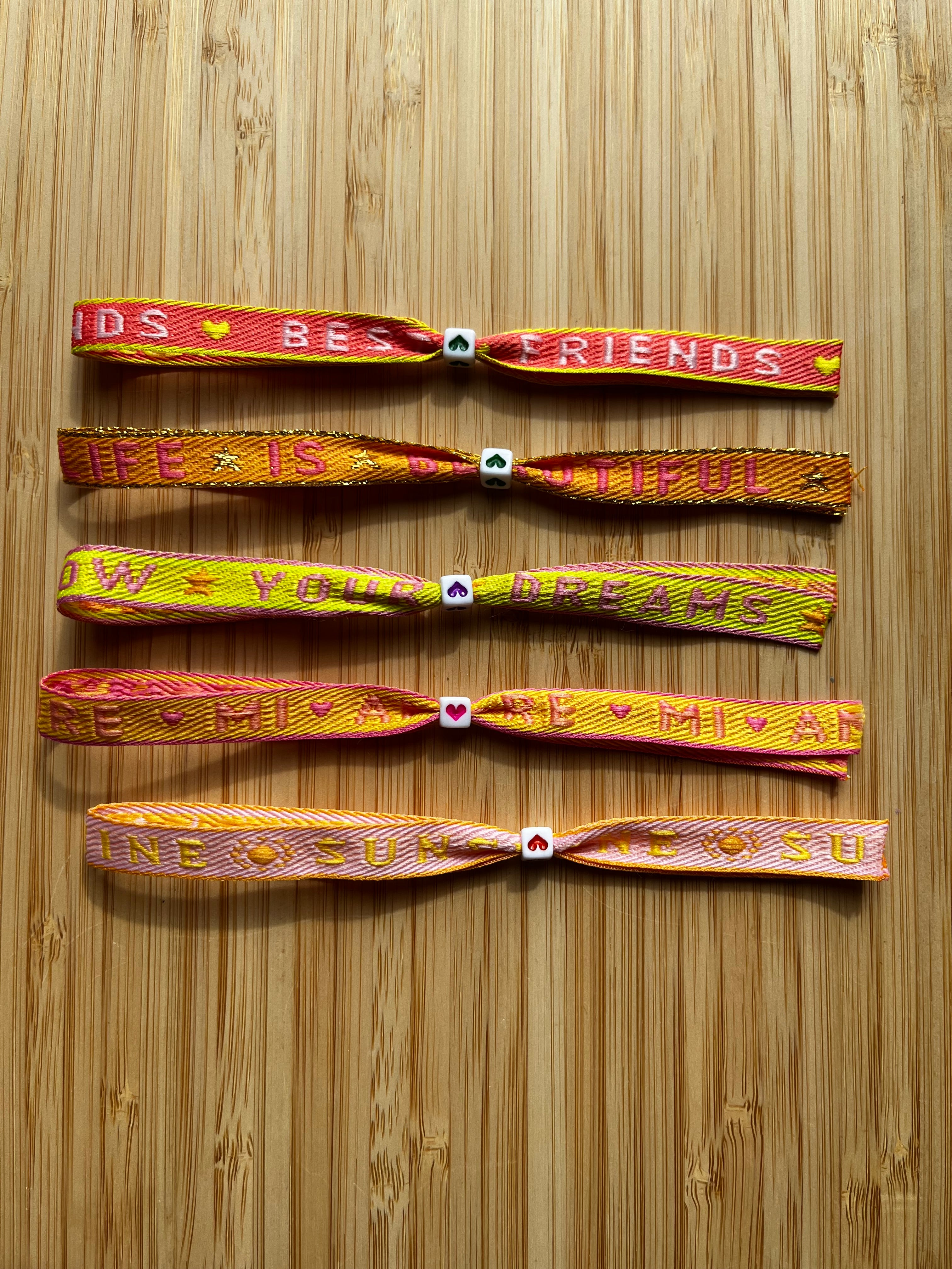 Zomerse lintarmbandjes met tekst in warme kleuren