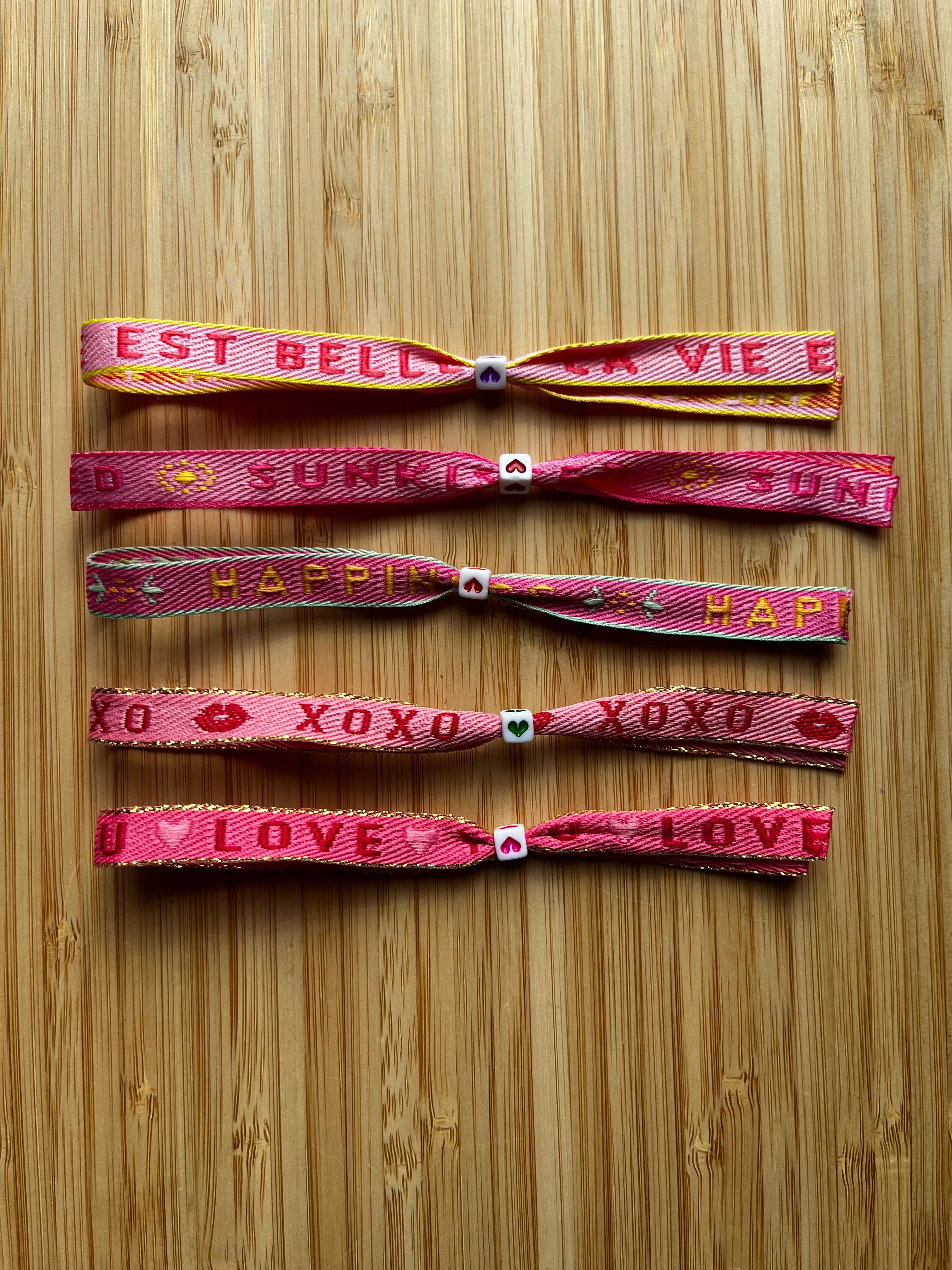 Zomerse lintarmbandjes met tekst in roze/rode kleuren