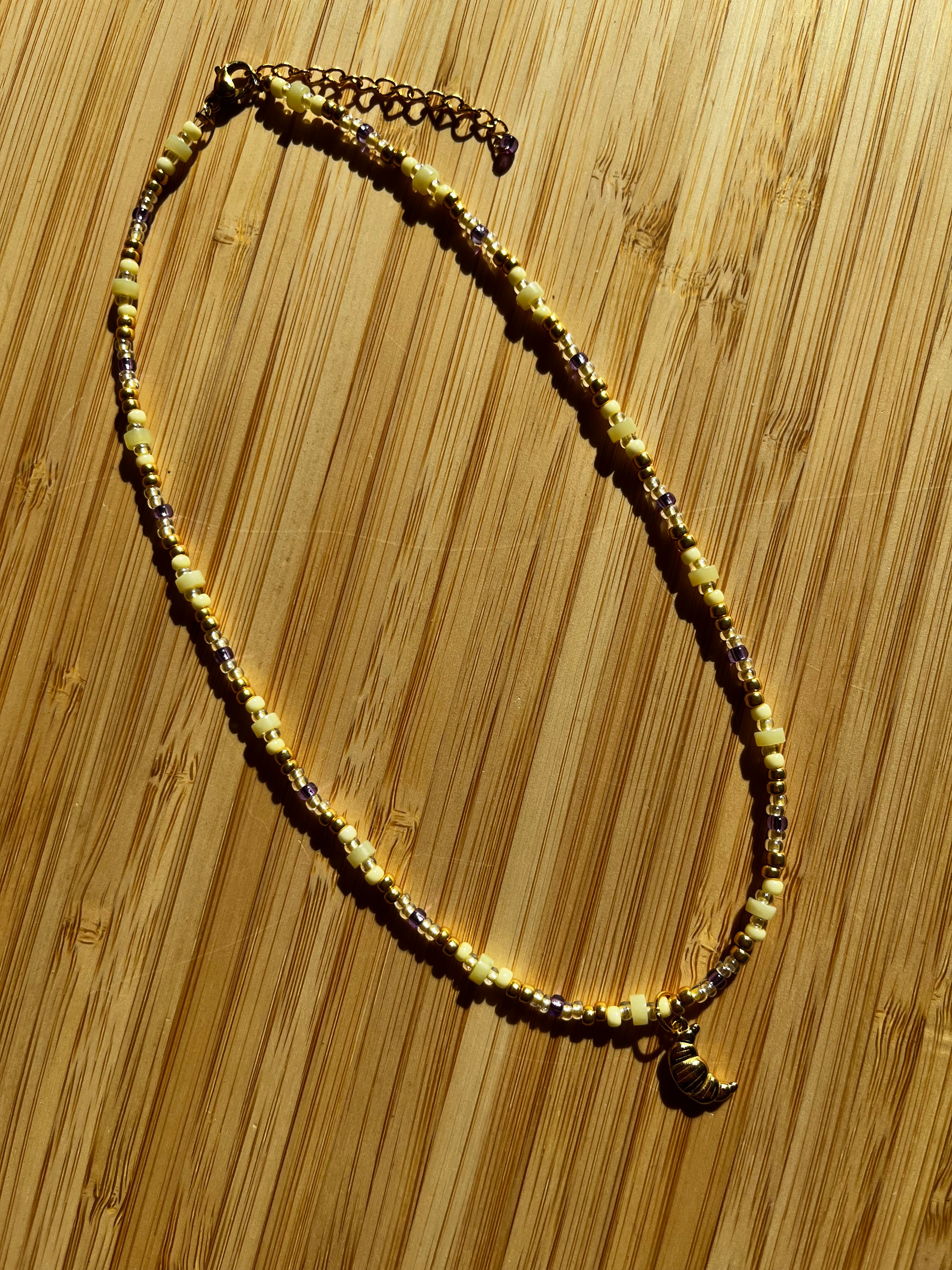 Kralenketting Lichtgeel & Paars met Croissant Bedel