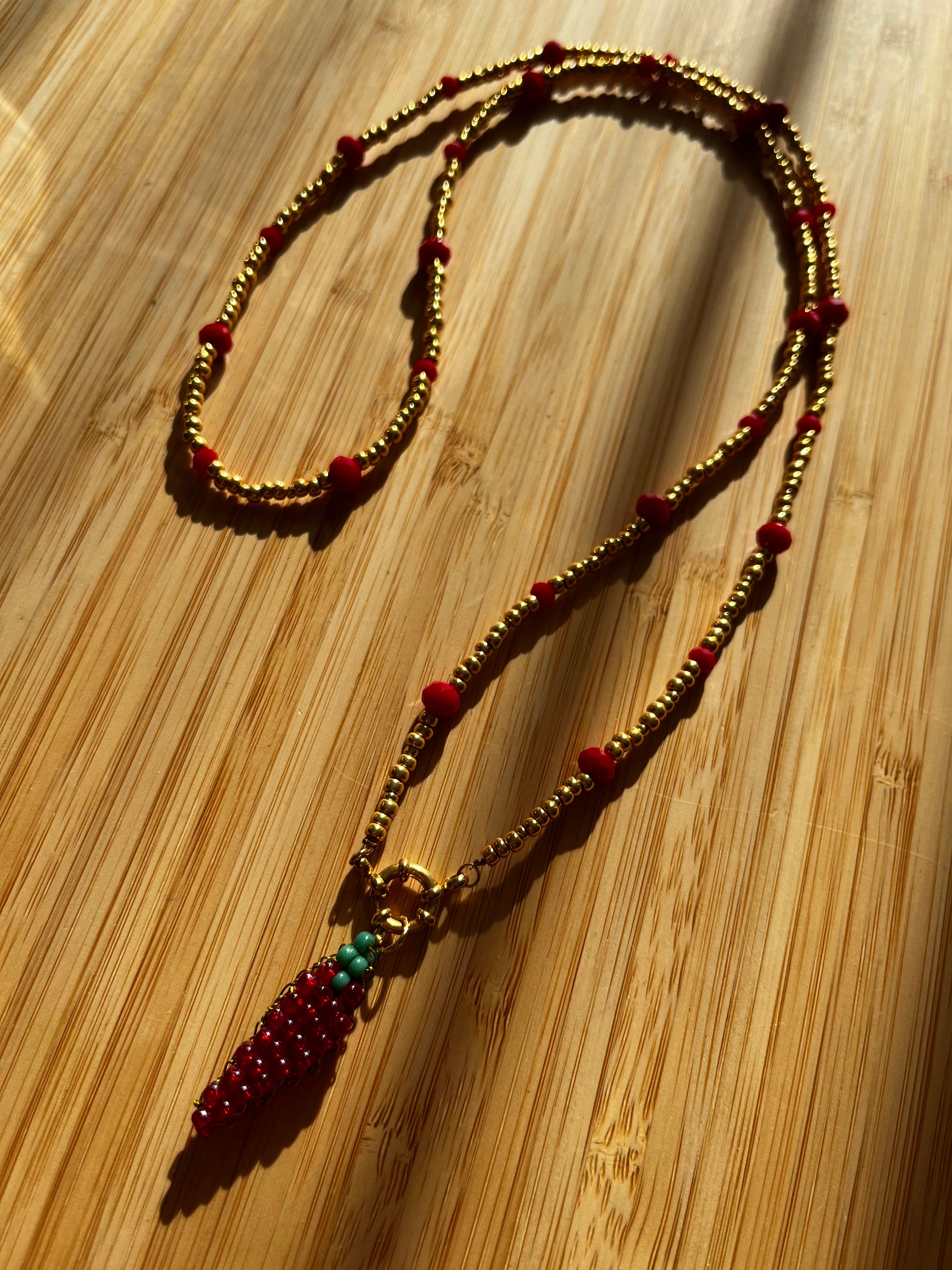 Lange Kralenketting Goud & Rood met Peper Bedel
